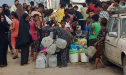 Des Palestiniens font la queue pour remplir des bidons d'eau, à al-Mawasi, dans le sud de la bande de Gaza, le 12 août 2025