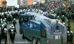 Des policiers marchent près d'un canon à eau pour disperser la manifestation de Pegida à Cologne le 9 janvier 2016