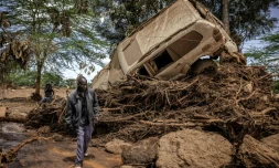 Un homme passe prÚs d'une voiture emportée par l'inondation dans le village de Kamuchiri (Kenya), prÚs de Mai Mahiu, le 29 avril 2024