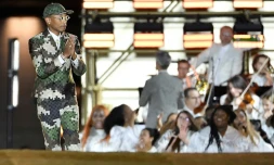 Le créateur américain Pharrell Williams salue le public à la fin de son défilé pour Louis Vuitton sur le Pont-Neuf à Paris, le 20 juin 2023