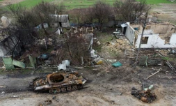 Epave d'un tank près de maisons détruites dans le village de Zalissya (Ukraine), au nord-est de Kiev, le 19 avril 2022