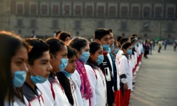 Des étudiants portant des masques pour se protéger des effets néfastes de la pollution lors d'une cérémonie Place Zocalo à Mexico le 17 mai 2019