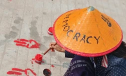Photo prise et diffusée le 14 avril 2021 par une source anonyme via Facebook d'une manifestante à Shwebo dessinant sur le sol le salut à trois doigts avec de la peinture rouge en signe d'opposition au coup d'Etat militaire en Birmanie