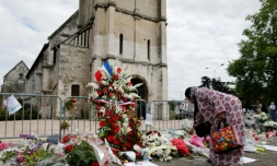 Une femme dĂ©pose des fleurs devant l'Ă©glise de Saint-Ătienne-du-Rouvray, le 29 juillet 2016