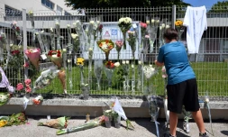 Un élève accroche des fleurs sur les grilles du collège Françoise-Dolto à Nogent, en Haute-Marne, au lendemain du meurtre d'une surveillante, le 11 juin 2025