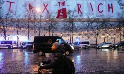 Une banderole géante "Tax the Rich" (taxez les riches) déployée par des militants d'Attac depuis le haut de la façade du futur hÎtel Vuitton sur les Champs-Elysées, à Paris, le 24 février 2024