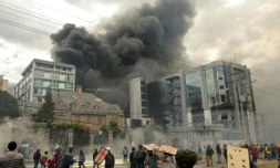 Des manifestants encagoulés mettent le feu au bureau de l'Inspection générale des finances, dans le nord de Quito, le 12 octobre 2019