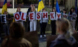 Des membres de la diaspora ukrainienne tiennent des pancartes formant le nom "Oleshky" (Olechky) devant l'ambassade américaine à Varsovie, le 6 octobre 2026