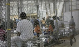 Des enfants et des adultes ayant traversé la frontière illégalement, attendent au centre de rétention McAllen au Texas, le 17 juin 2018