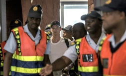 L'ex-capitaine de l'équipe nationale australienne de cricket Steve Smith (centre) quitte l'aéroport de Johannesburg, suite au scandale de la balle trafiquée qui a ébranlé le monde du cricket et l'Australie.