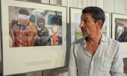 Le photographe français Frédéric Lafargue pose devant sa série de photos intitulée "Echapper à Daech", le 1er septembre 2016 à Perpignan