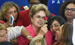 La présidente brésilienne Dilma Rousseff reçoit une rose lors d'une rencontre intitulée "Des femmes en défense de la démocratie" à Brasilia le 7 avril 2016