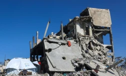 Un Palestinien devant sa tente, à côté des ruines d'un immeuble à Jabalia, dans le nord de la bande de Gaza, le 27 février 2025
