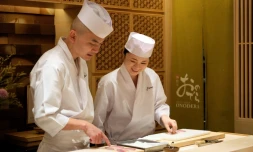  Mizuho Iwai (d) apprend auprès d'un maitre sushi dans le restaurant Onodera à Tokyo, le 27 novembre 2019 la façon de préparer le poisson