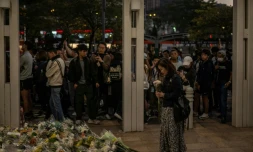 Des habitants de Hong Kong déposent des fleurs devant un complexe résidentiel ravagé par un incendie, le 29 novembre 2025