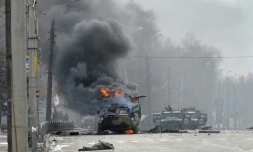 Un blindé en feu et le corps d'un soldat dans une rue de Kharkiv, seconde ville ukrainienne, le 27 février 2022
