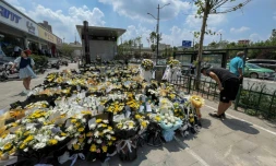 Un homme dépose des fleurs devant une station de métro en mémoire des victimes des inondations à Zhengzhou, dans la province centrale chinoise du Henan, le 27 juillet 2021