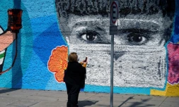 Une femme prend une photo d'une fresque dédiée aux soignants de la crise du Covid-19 à Mexico le 9 décembre 2020
