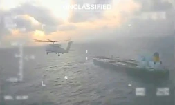 Image tirée d'une vidéo publiée sur le compte X de la secrétaire américaine à la Sécurité intérieure, Kristi Noem, montrant un avion des garde-cÎtes américains survolant un pétrolier, amarré au Venezuela, avant de l'intercepter le 20 décembre 2025