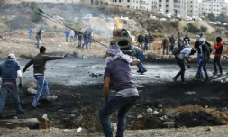 Des Palestiniens lancent des pierres vers des soldats israéliens dans les environs de Ramallah, le 27 octobre 2015