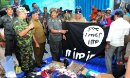 Les forces de l'ordre devant des objets saisis aprÚs l'assaut lancé contre une cache de jihadistes, à Kalmunai, au Sri Lanka, le 26 avril 2019