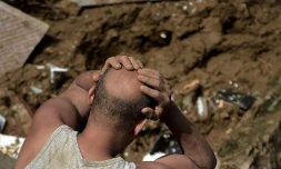 Un homme réagit devant les dégùts laissés par un glissement de terrain à Petropolis (sud-est du Brésil), le 16 février 2022