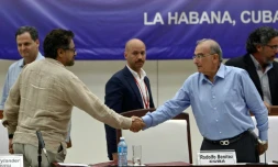 Ivan Marquez, négociateur pour les FARC (G) serre la main à Humberto de la Calle (D), chef de la délégation gouvernementale, à La Havane (Cuba), le 5 août 2016