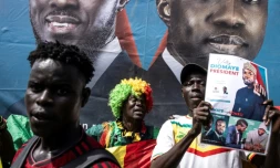 Un partisan brandit une affiche avec le candidat présidentiel sénégalais Bassirou Diomaye Faye et le leader de l'opposition Ousmane Sonko lors d'un rassemblement à Dakar le 10 mars 2024