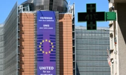 Un thermomètre de pharmacie affiche 41°C, avec en arrière-plan le siège de la Commission européenne, à Bruxelles, le 23 juin 2025