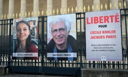 Les portraits de Cécile Kohler et Jacques Paris, détenus en Iran, devant l'Assemblée nationale à Paris, le 25 mars 2025