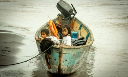 Des enfants ont trouvé refuge dans une pirogue sur la rivière Coca souillée par du pétrole à Puerto Maderos en Équateur, le 1er février 2022