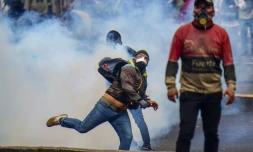Un manifestant renvoie une cartouche de gaz lacrymogène pendant une manifestation à Quito, en Equateur, le 11 octobre 2019