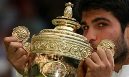 L'Espagnol Carlos Alcaraz embrasse le trophée du vainqueur après avoir battu le Serbe Novak Djokovic lors de la finale de Wimbledon 2023, au sud-ouest de Londres, le 16 juillet 2023