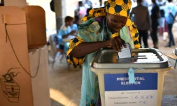 Une femme glisse son bulletin dans l'urne lors des élections générales au Sierra Leone, le 7 mars 2018 à Freetown
