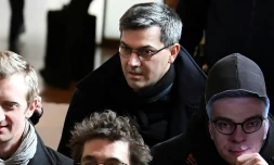 Le chef du groupe dit "de Tarnac" Julien Coupat arrive au procĂšs avec une personne portant le masque du procureur Olivier Christen, le 13 mars 2018