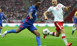 L'attaquant anglais Raheem Sterling, aux prises avec le défenseur polonais Tymoteusz Puchacz, lors des qualifications européennes pour le Mondial-2022 au Qatar, le 8 septembre 2021 à Varsovie