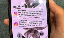 Un adolescent tient un téléphone portable affichant un message du réseau social Instagram aprÚs que son compte a été verrouillé en raison de son ùge, à Sydney, le 9 décembre 2025
