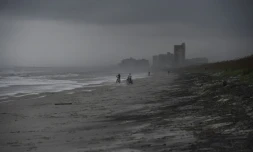 Des cyclistes sur une plage d'Atlantic Beach balayée par des vents violents, le 5 octobre 2016 en Floride à l'approche de l'ouragan Matthew  