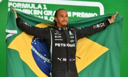 Le pilote britannique Lewis Hamilton (Mercedes) célèbre sur le podium, avec le drapeau brésilien, sa victoire dans le Grand Prix du Brésil de Formule 1, le 14 novembre sur le circuit d'Interlagos à Sao Paulo