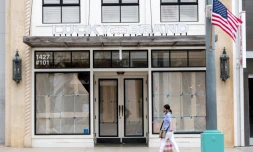 Une passante portant un masque marche devant un magasin fermé à Santa Monica en Californie, en pleine épidémie de coronavirus, le 28 juillet 2020