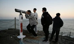 des touristes observent le détroit de Taïwan, sur l'ßle chinoise de Pingtan, le 13 janvier 2024