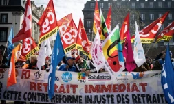 Mobilisation contre la réforme des retraites de manifestants brandissant des drapeaux de syndicats, le 28 mars 2023 à Clermont-Ferrand
