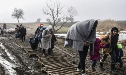 Des migrants traversent un champ boueux aprÚs avoir passé la frontiÚre serbo-macédonienne prÚs du village serbe de Miratovac, le 27 janvier 2016
