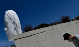 Devant la sculpture "Julia" de l'artiste espagnol Jaume Plensa sur la Plaza ColĂłn Ă Madrid le 21 mai 2020
