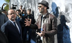 Le président François Hollande (g) et l'artiste JR (d), le 19 avril 2017 à Clichy-sous-Bois en banlieue parisienne