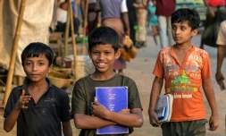 Des enfants réfugiés rohingyas portent leurs manuels scolaires au camp de réfugiés de Kutupalong, le 17 décembre 2025 à Ukhia, au Bangladesh