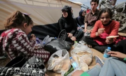 Des manifestants palestiniens mangent prÚs d'une tente le 30 mars 2018 lors d'une manifestation prÚs de la frontiÚre avec Israël, dans le sud de la bande de Gaza