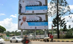 Un homme devant des affiches annonçant la visite du Pape François le 23 novembre 2015 à Nairobi
