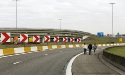 Des gens marchent sur une autoroute à la circulation fermée menant à l'aéroport de Bruxelles le 22 mars 2016