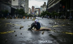 Un opposant à Nicolas Maduro assis dans la rue pendant un blocage le 19 juillet 2017 à Caracas.